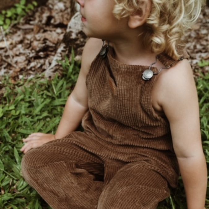 boy sitting down wearing his brown Kids and toddlers corduroy overalls or dungarees