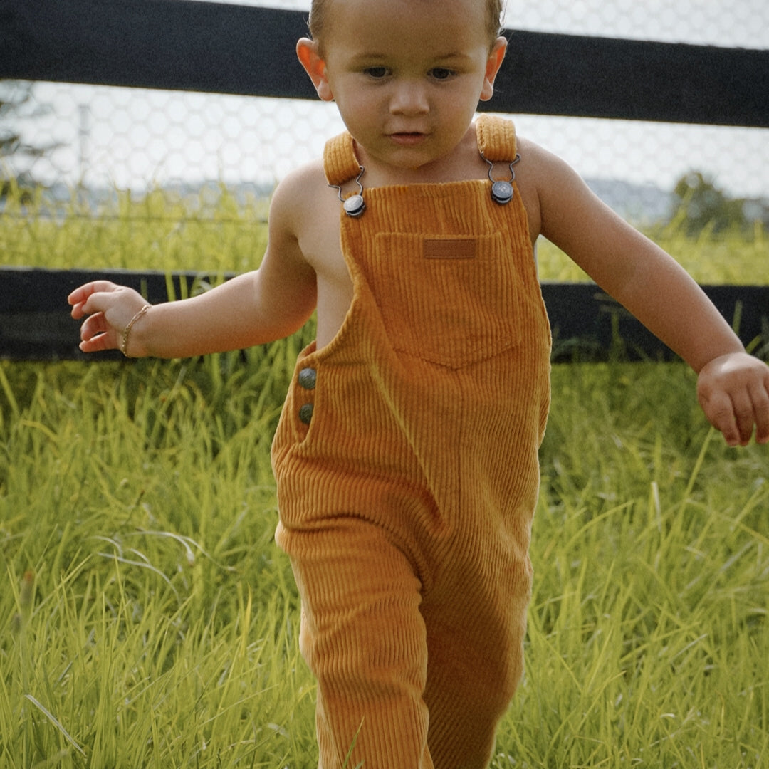 organic cotton corduroy long leg overalls in a orange for kids, toddlers and infants front view