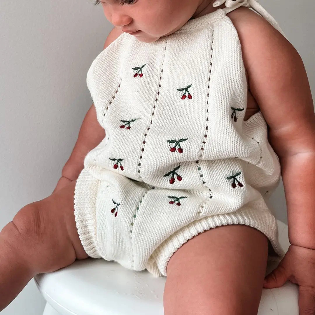 organic cotton romper for babies ages 0 - 24 months. Croquet style romper in beige with Cherry embroided into it front view