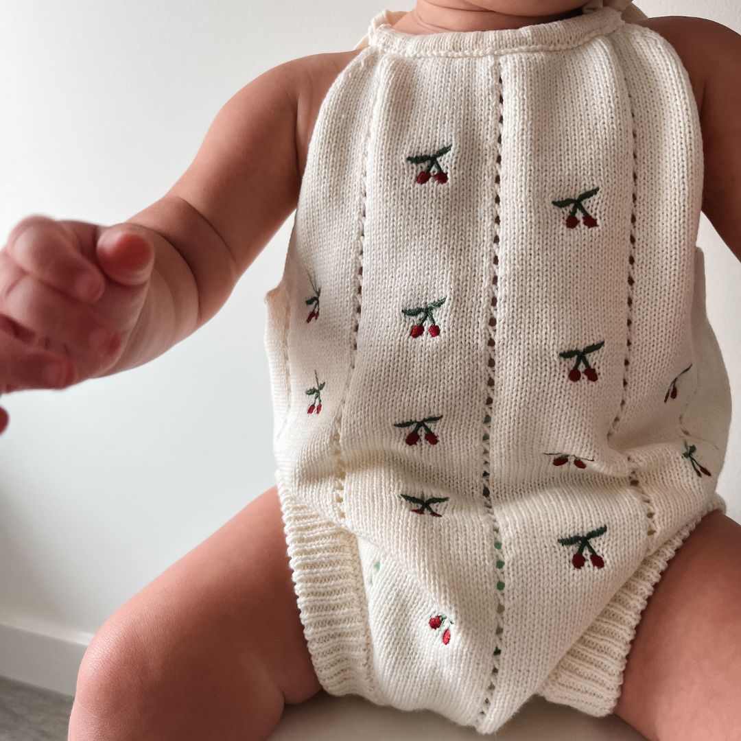organic cotton romper for babies ages 0 - 24 months. Croquet style romper in beige with Cherry embroided into it sitting front view