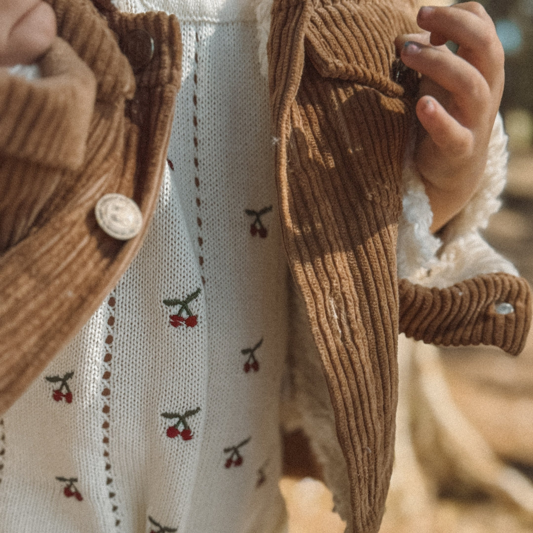 toddler wearing a corduroy jacket with sherpa fleece made from organic side view